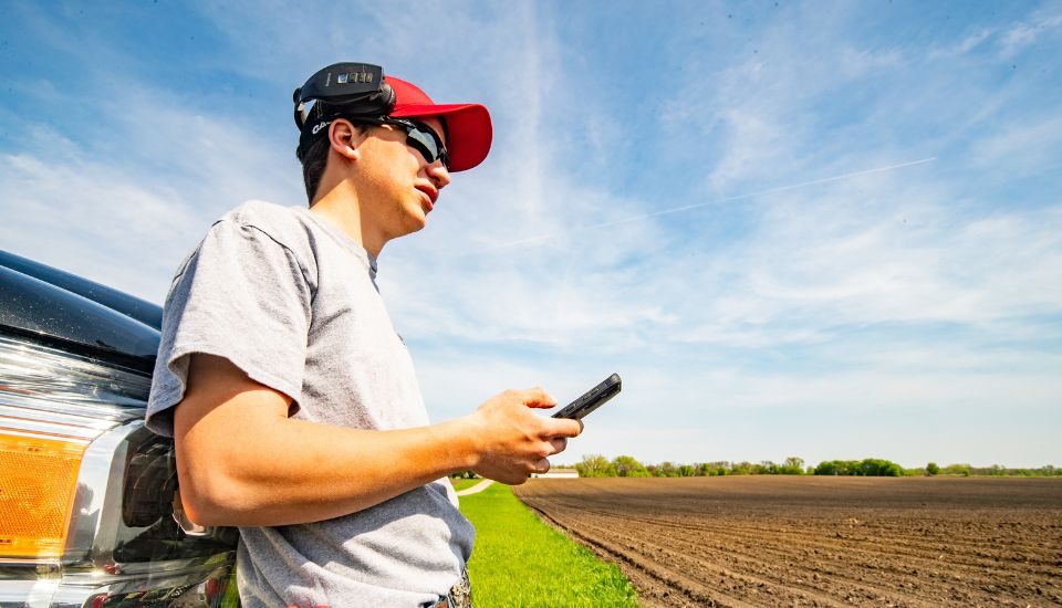 Man holding a phone in a field