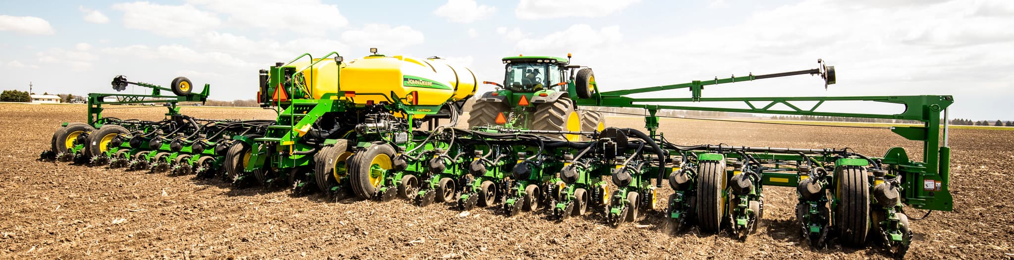 Tractor pulling a crop sprayer through a field